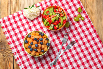 Delicious fruit salads in bowls on table