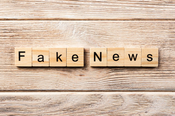 fake news word written on wood block. fake news text on table, concept