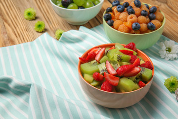 Delicious fruit salads in bowls on table