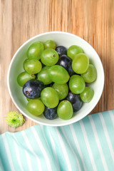 Delicious grape salad in bowl on wooden table