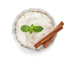 Delicious rice pudding with cinnamon in bowl on white background
