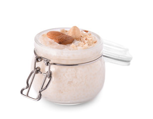 Delicious rice pudding with nuts in jar on white background