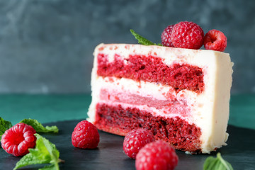 Piece of delicious raspberry cake on slate plate, closeup