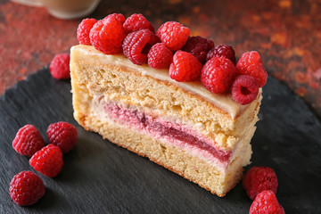 Piece of delicious raspberry cake on slate plate, closeup