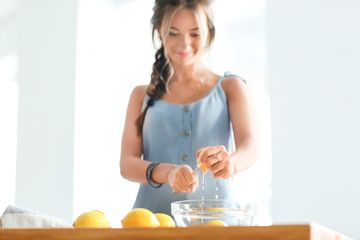 Young woman preparing fresh lemonade at home