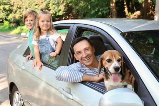 Happy Family With Cute Dog Sitting In Car