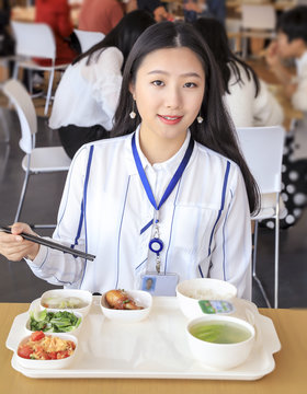 Asian Female White-collar Worker Eating In The Cafeteria