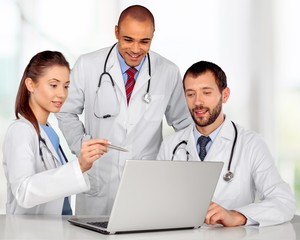 Doctors team talking expertise in hospital by laptop