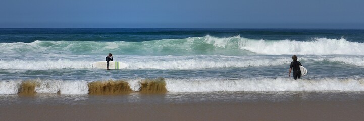deux surfeurs attendent la vague