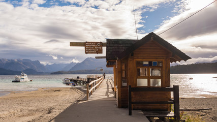 Patagonian wooden pier / In a lake, with mountains in the horizon and the sun coming from the side