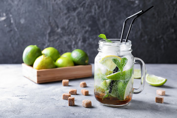 Mason jar of fresh mojito on grey table