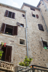 bottom view of a medieval stone house with Windows and wooden shutters in the old town of Kotor, Montenegro