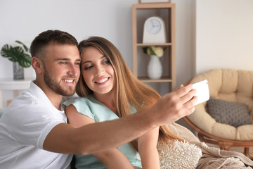 Happy loving couple taking selfie at home