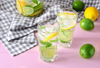 Glasses of fresh lime lemonade on color table