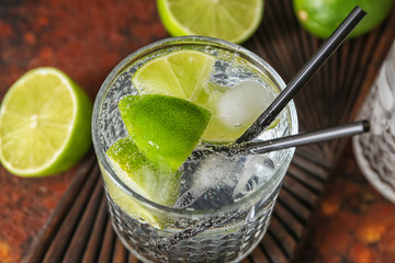 Glass of fresh lime lemonade on table, closeup
