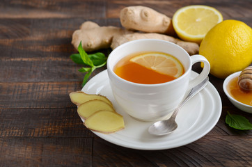 Ginger root tea with lemon and honey on wooden background, selective focus, copy space.