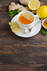 Ginger root tea with lemon and honey on wooden background, selective focus, copy space.