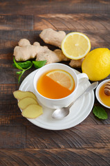 Ginger root tea with lemon and honey on wooden background, selective focus, copy space.