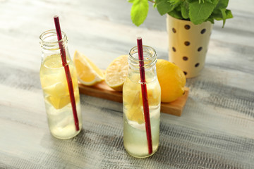 Bottles of fresh lemonade on wooden table