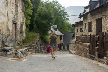 woman walking on foot a mountain village in spring in the Pyrenees