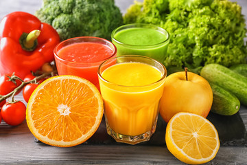 Glasses of tasty smoothies with ingredients on wooden table