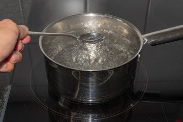 Löffel über kochendem Wasser in der Pfanne
