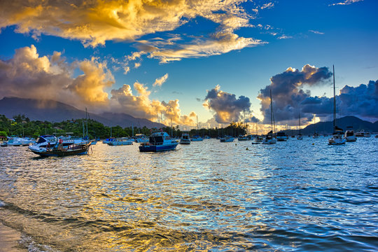  Ilhabela beach Saco da capela with boats and sailboats in the sea at sunset - Sao Paulo, Brazil                           