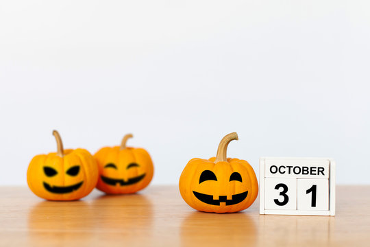 Wooden cubes with the numbers 31 october and pumpkin on wood table with white background. Halloween celebration concept. copy space