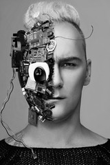 Monochrome studio portrait of man cyborg, half face computer elements and with professional...