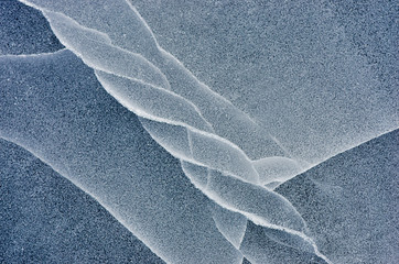 Fototapeta na wymiar Blue cracked surface of the ice surface