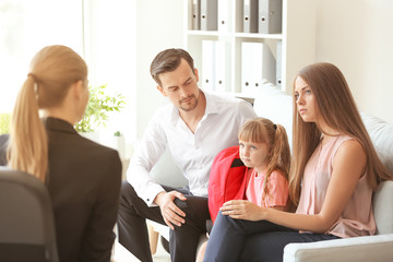 Young couple and their daughter meeting with headmistress at school