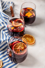 Glasses of delicious mulled wine on light table