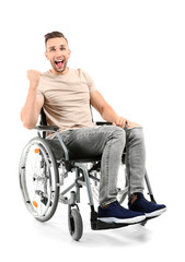 Happy young man sitting in wheelchair on white background
