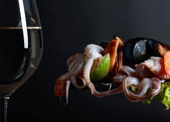 Glass of white wine and mixed delicious seafood.