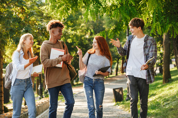 Group of excited students walking at the campus
