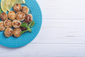 Fried scallops with lemon and salad