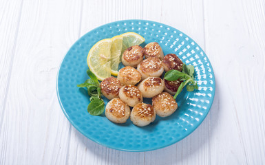 Fried scallops with lemon and salad
