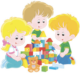 Small children playing with multicolor bricks and building a toy castle