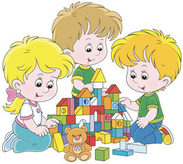 Small children playing with multicolor bricks and building a toy castle