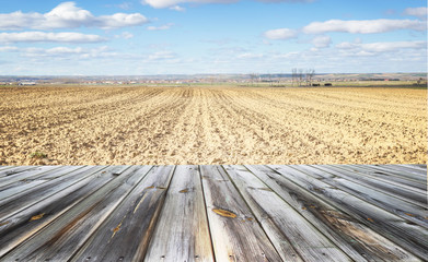 Wooden table top with autumn agricultural field. Space for present a product