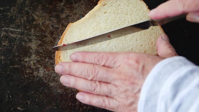 A woman cuts a fruit, cream cheese and jam in half, and shows the filling