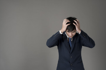 Business man is headache ,grey background in studio