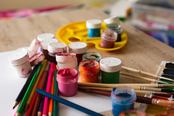Watercolor Pallet, Oil Paints, Brushes Set and Wooden Color Pencils for Painting,  on Wooden background, Close up.