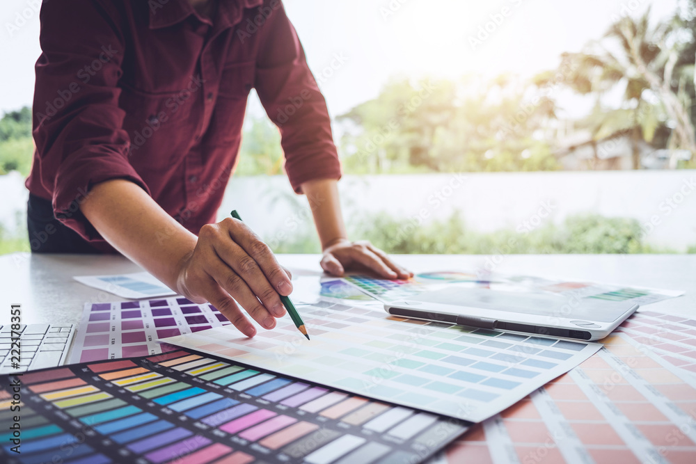 Aufkleber image of male creative graphic designer working on color selection and drawing on graphics tablet at