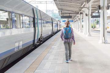 Female tourist walking along platform to catch train