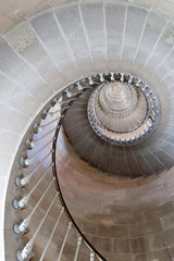 Looking up circular lighthouse stairs made of stones.