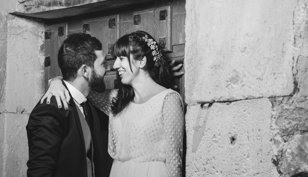 Young bride and groom standing together near wall