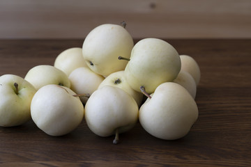 Apples on an  wooden surfaces. Pale yellow apples on an dark old wooden table.
