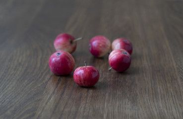 Red apples on a dark wooden table.