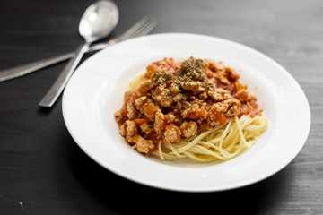 Spaghetti on black wooden background